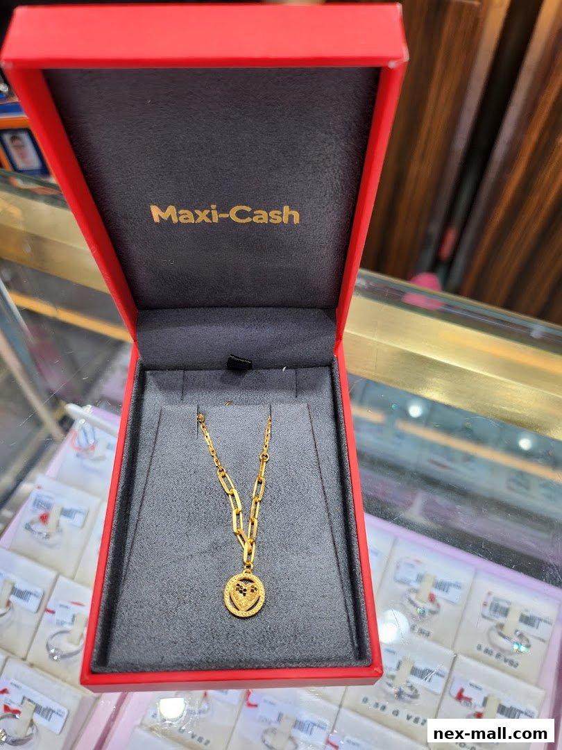 A gold necklace with a circular pendant displayed in a red jewelry box.