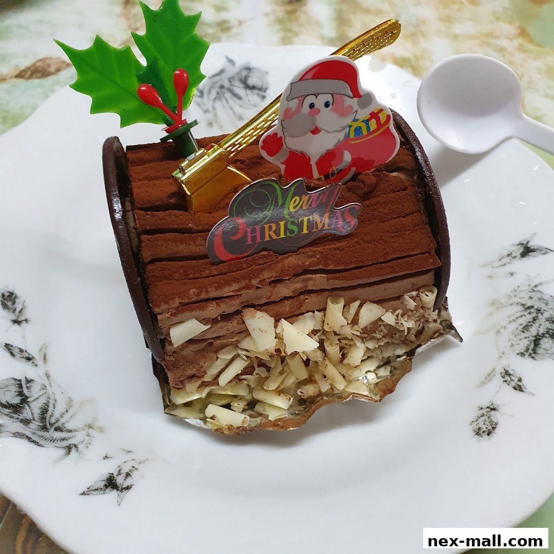 A festive chocolate log cake decorated with Santa and holly for Christmas.