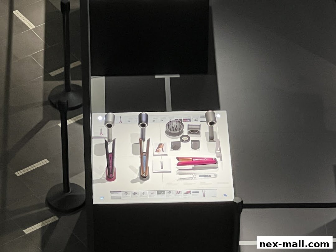 Dyson hair styling products displayed on a white stand with informational graphics.