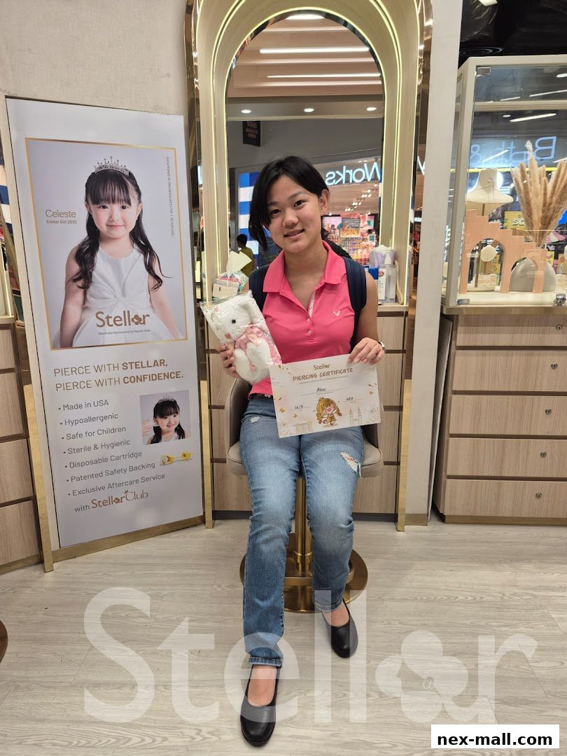 A young girl holds a piercing certificate and a stuffed toy at Stellar NEX Ear Piercing Jewellery.