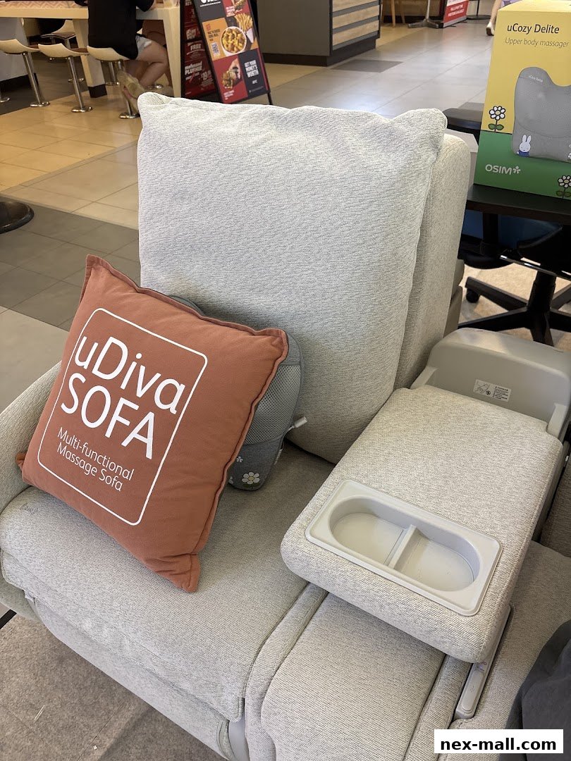 A close-up of a comfortable massage sofa with a "uDiva SOFA" pillow and a product box in the background.