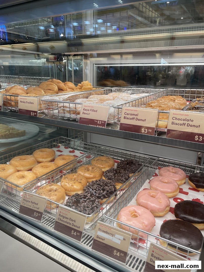 A display case filled with various freshly baked donuts and pastries at Tim Hortons.