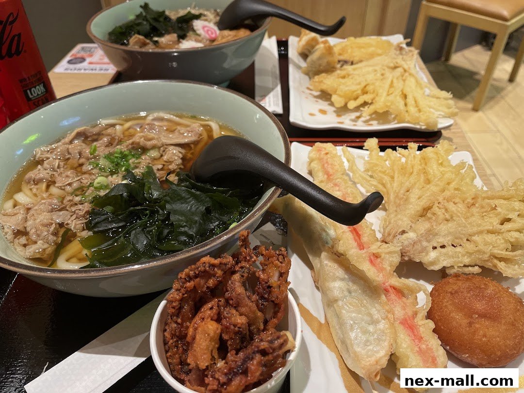 A close-up of delicious udon noodles and various tempura dishes served at a restaurant.