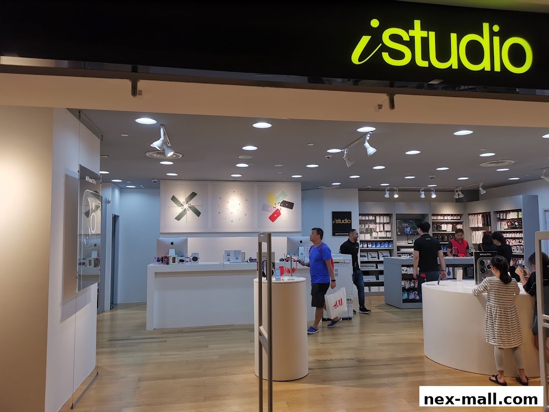 The entrance of an iStudio store, showcasing Apple products and accessories with customers inside.