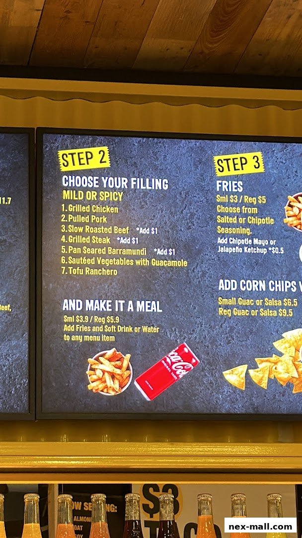 A digital menu board displays options for choosing fillings, making it a meal, and fries at Guzman y Gomez.