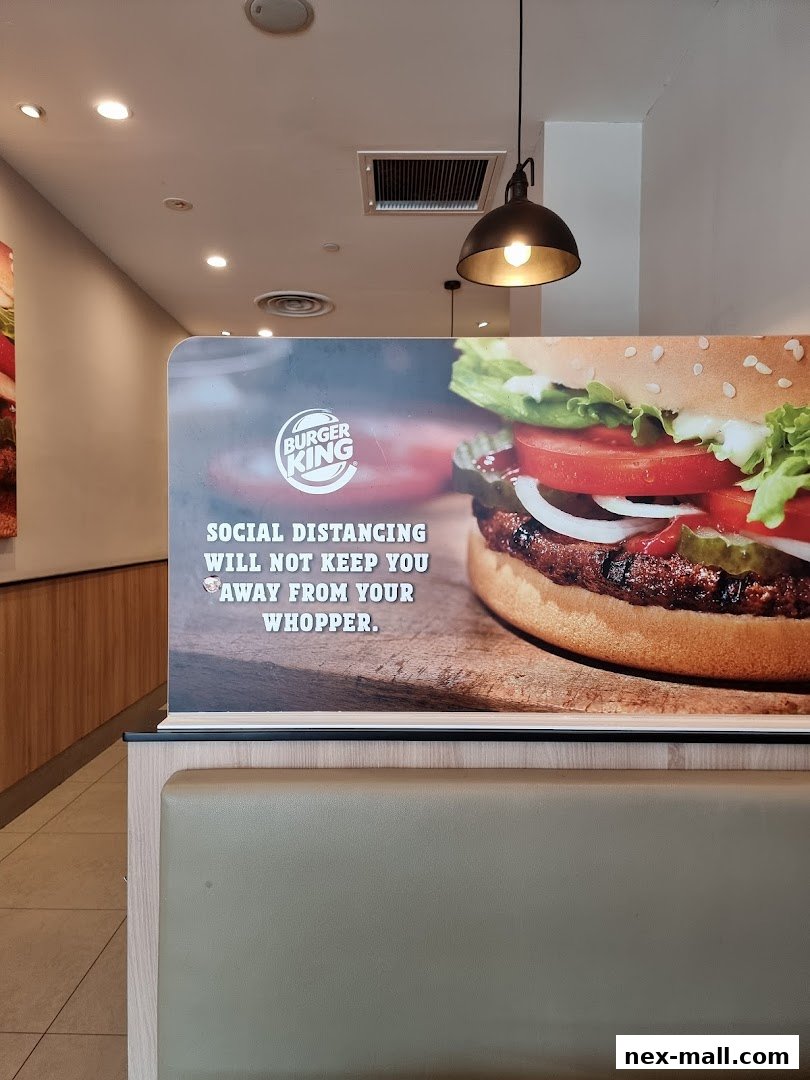 Burger King interior with a large Whopper image and social distancing message.