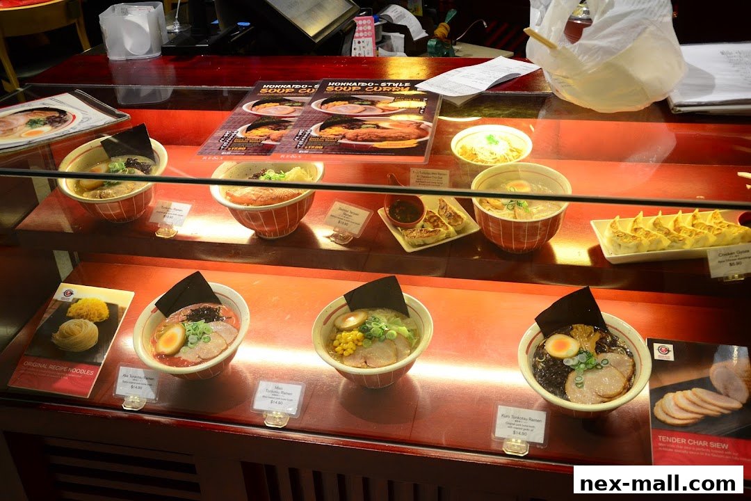 A display case filled with various ramen bowls and gyoza, showcasing Japanese food.