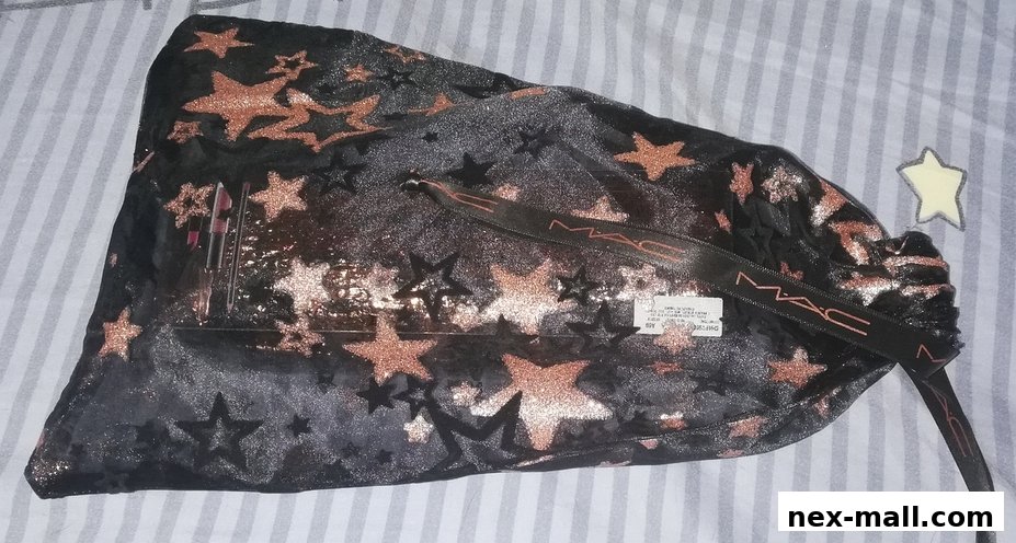 A black makeup bag with rose gold stars and MAC branding, containing lipsticks.