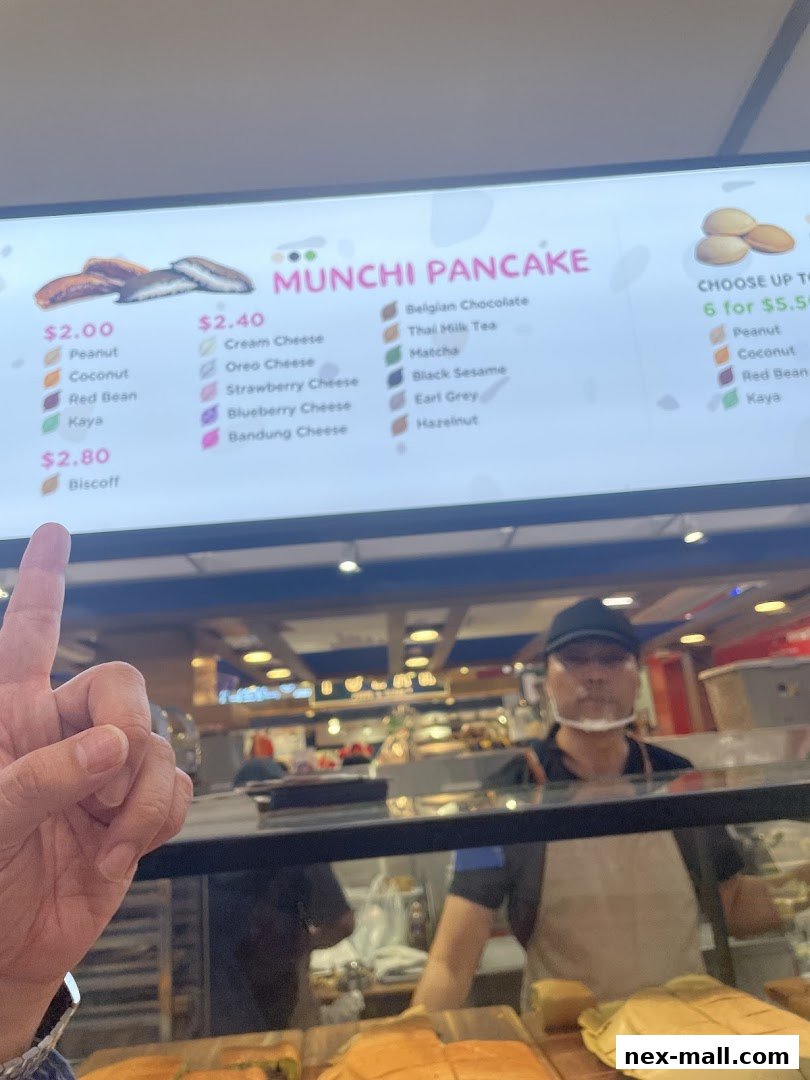 A menu board displaying various pancake flavors and prices at Munchi Pancake.