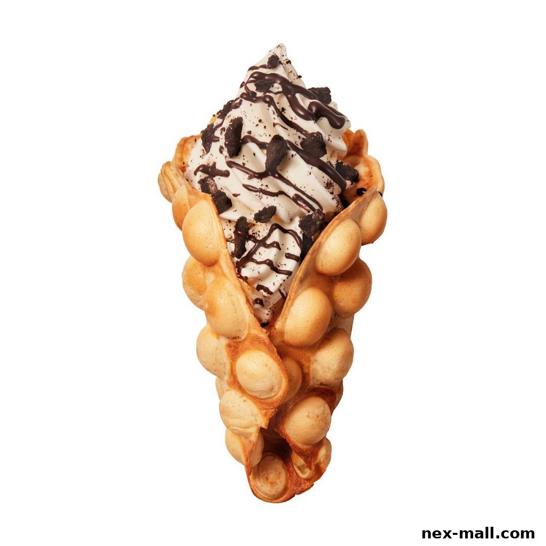 A delicious bubble waffle cone filled with soft-serve ice cream and topped with chocolate sauce and cookie crumbles.
