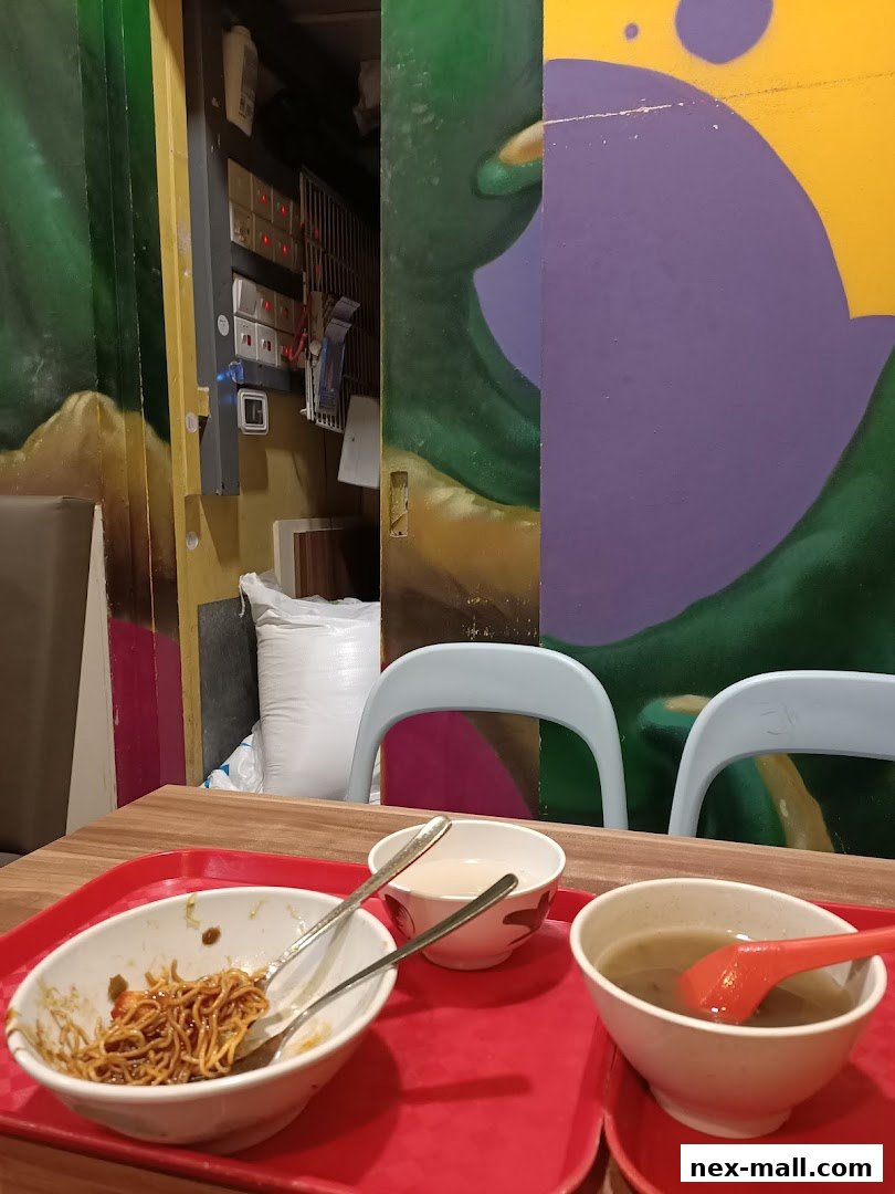 A table with bowls of noodles and soup, set against a backdrop of colorful graffiti art.