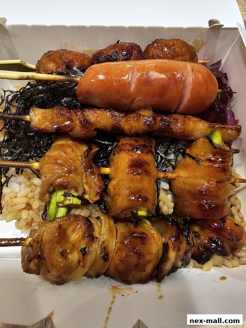 A bento box filled with various grilled skewers and rice.