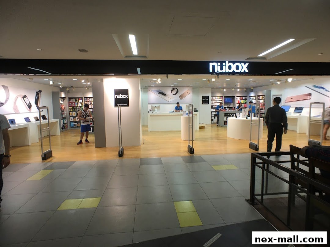 The entrance of a modern electronics store, showcasing Apple products and accessories.