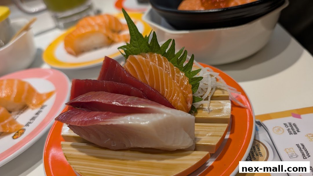 A close-up of fresh sashimi and sushi on plates at Genki Sushi NEX.