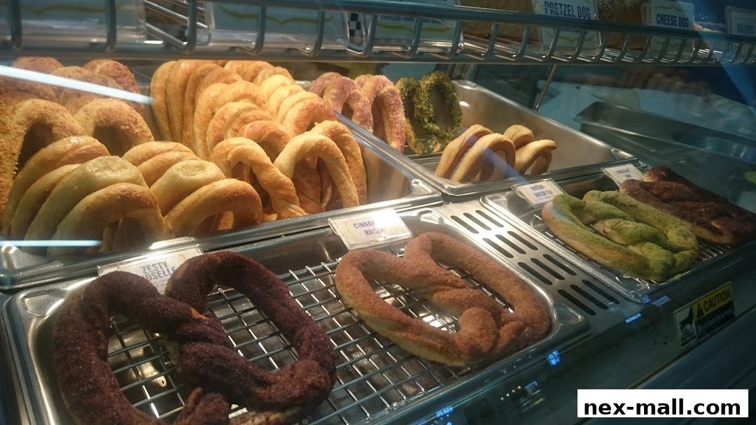 A display case filled with various freshly baked pretzels in different flavors.