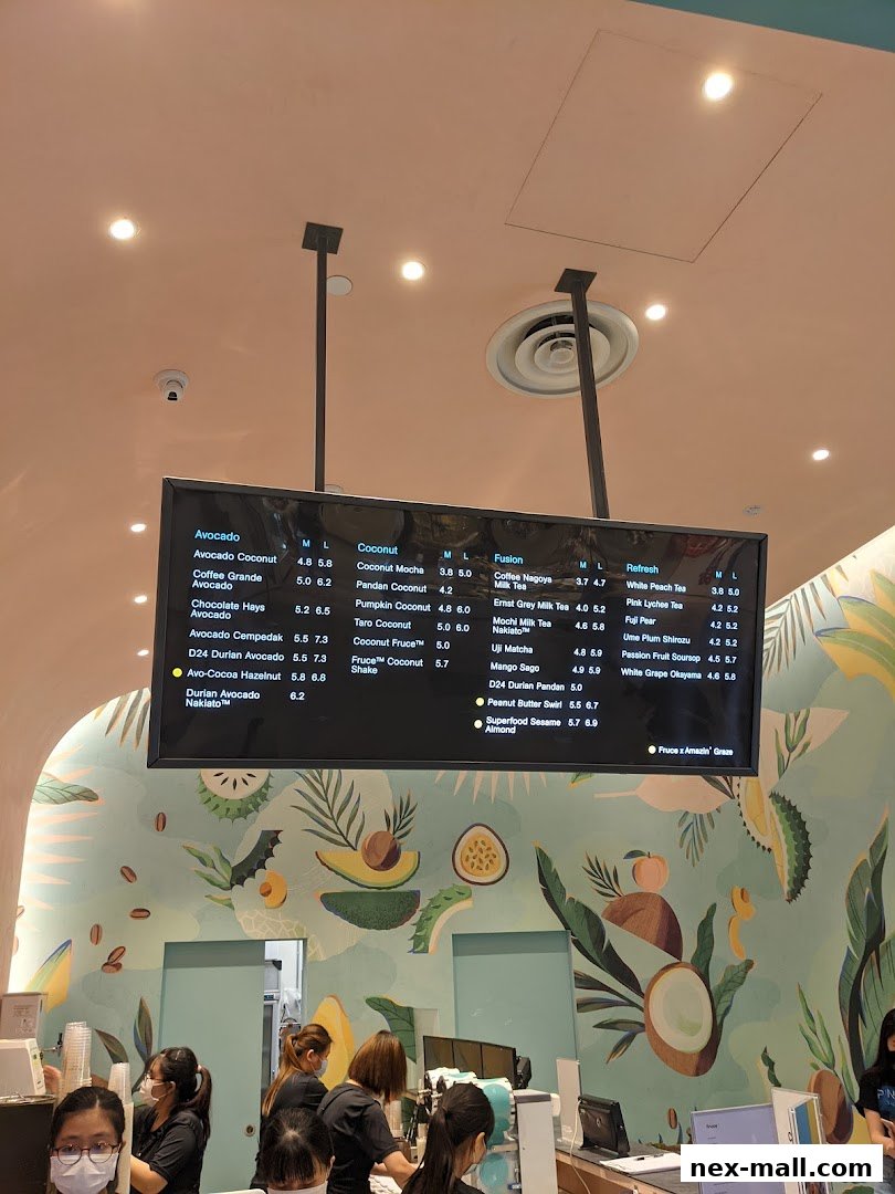 A digital menu board displaying various drinks and their prices at Fruce NEX.