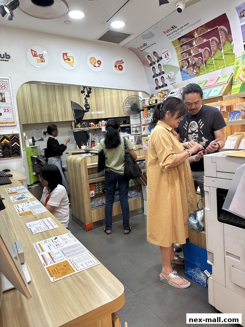 Customers interacting with staff inside a photo printing and passport photo service shop.