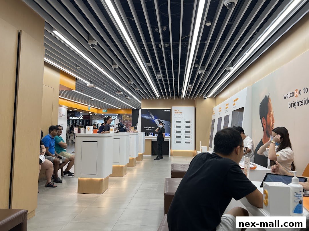 Interior of a bright, modern phone shop with customers and staff at service counters.
