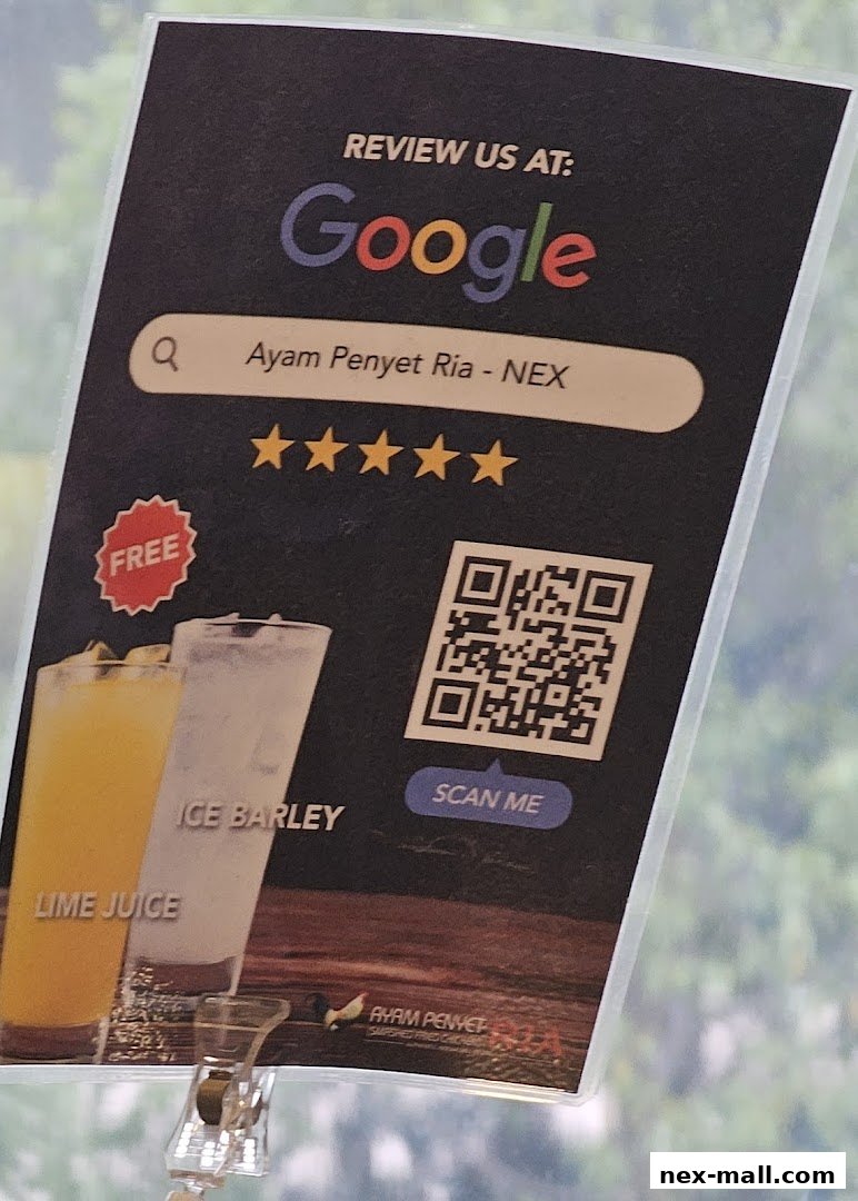 A sign encouraging customers to review Ayam Penyet Ria - Nex on Google.