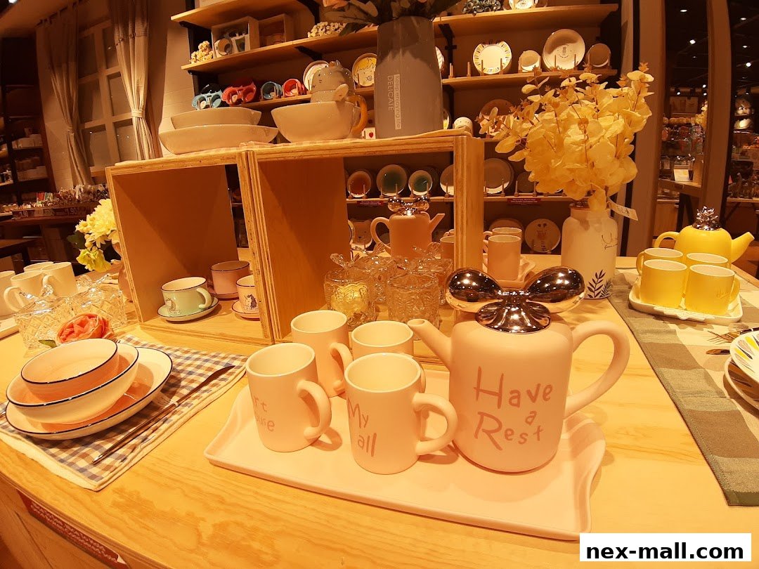 A display of pink and yellow teapots and mugs on a wooden counter.