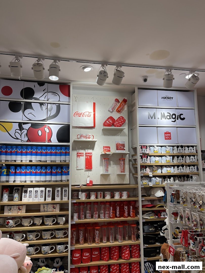 A MINISO NEX store interior showcasing a variety of Coca-Cola and Mickey Mouse themed merchandise.