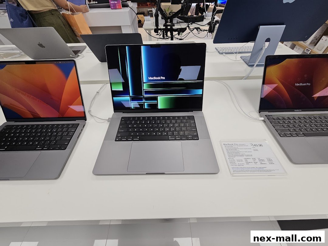 Display of Apple MacBook Pro laptops on a white counter in a retail store.