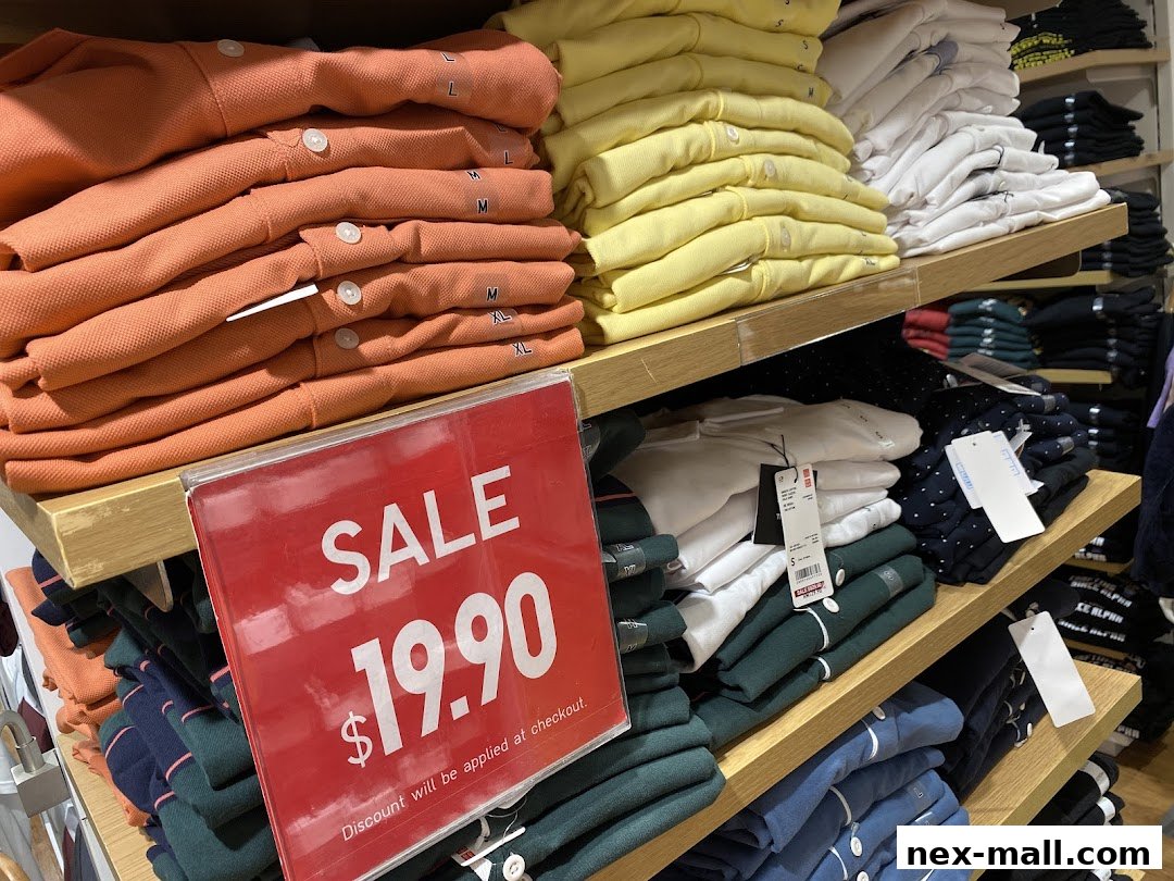 Shelves stocked with folded polo shirts in various colors, with a prominent sale sign.
