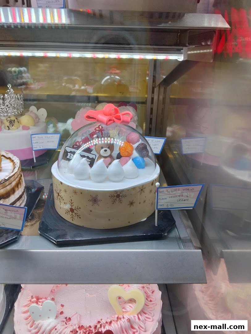 A display case filled with beautifully decorated cakes, including a teddy bear cake.