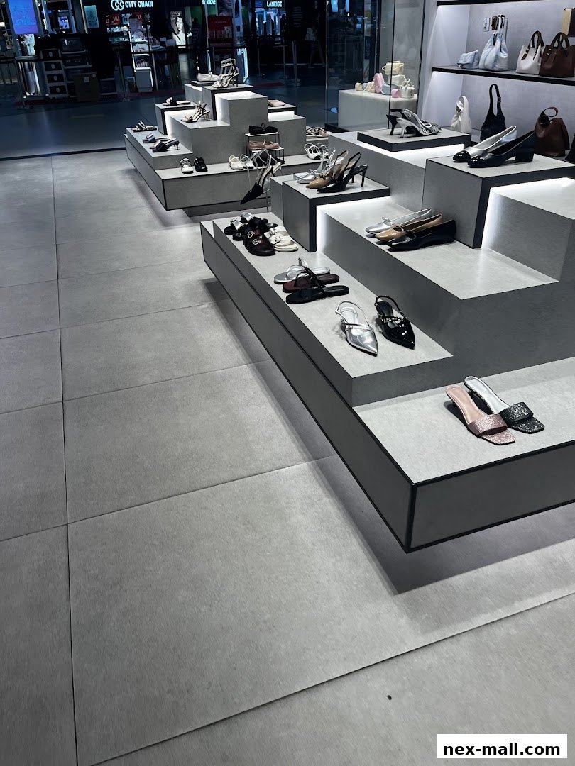 A modern shoe store display featuring various heels, flats, and sandals on tiered platforms.