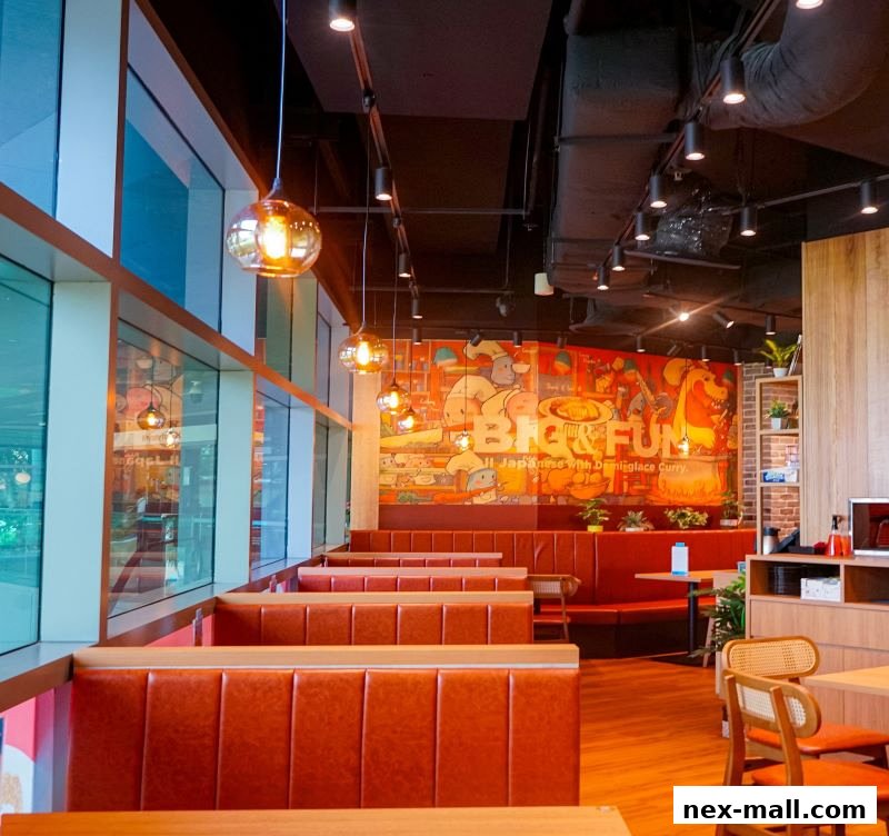 Interior of a restaurant with orange booth seating and a colorful mural on the wall.