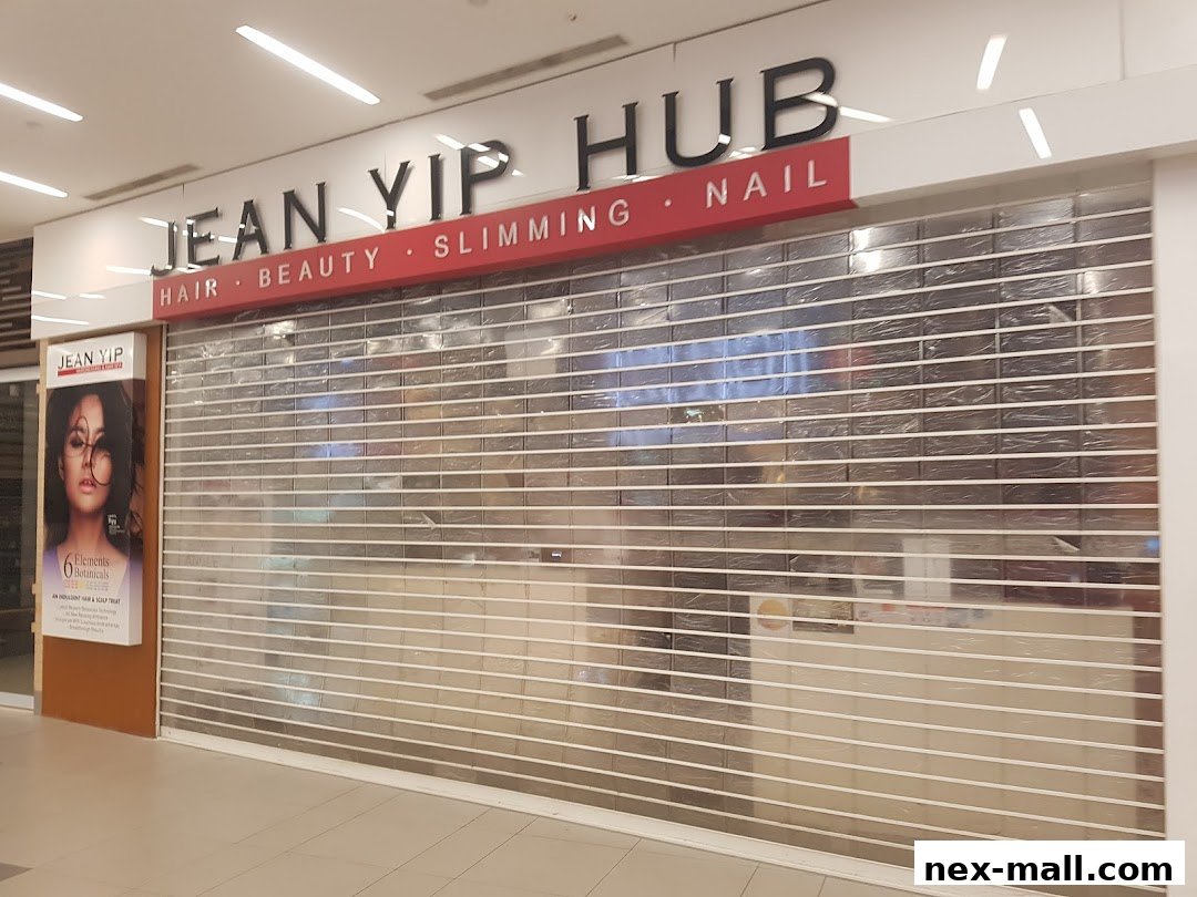 The Jean Yip Hairdressing NEX shop front with its roller shutter down.