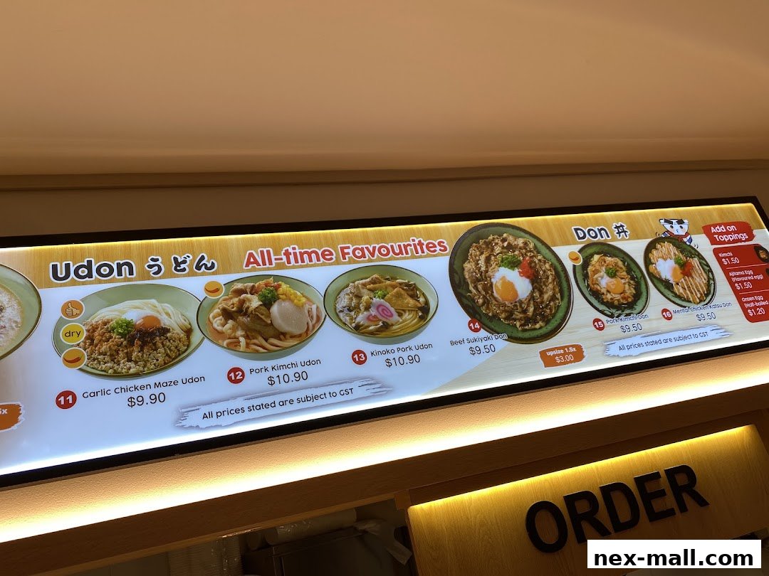 A brightly lit menu board showcasing various Udon and Donburi dishes with prices.