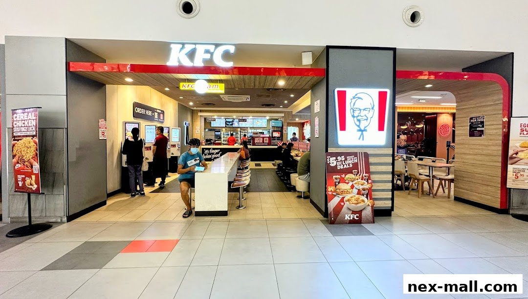The entrance of a KFC restaurant with customers ordering and dining inside.