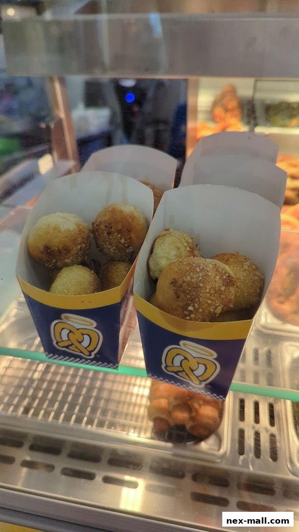 Two containers of pretzel bites with a golden-brown crust and sprinkled toppings.