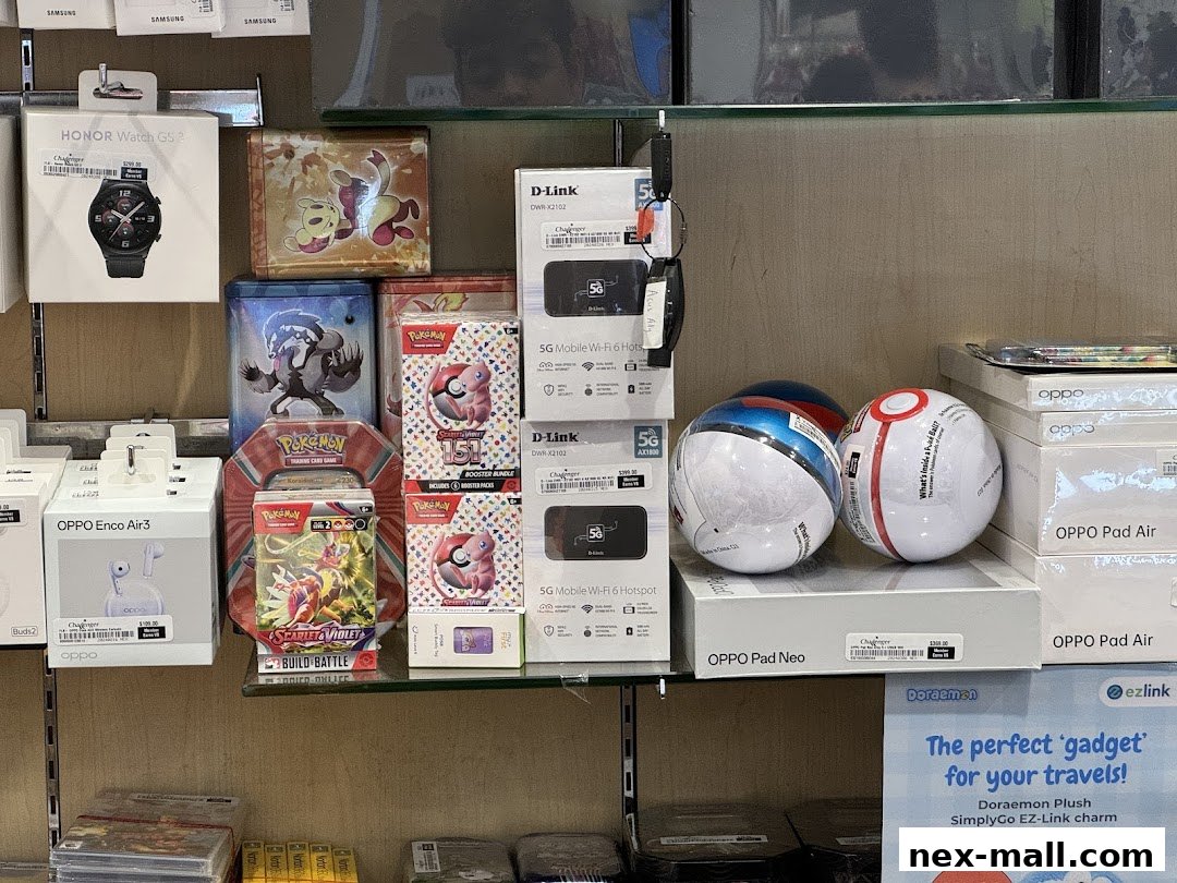 A retail display featuring electronics like smartwatches, earbuds, Wi-Fi hotspots, and Pokémon trading cards.
