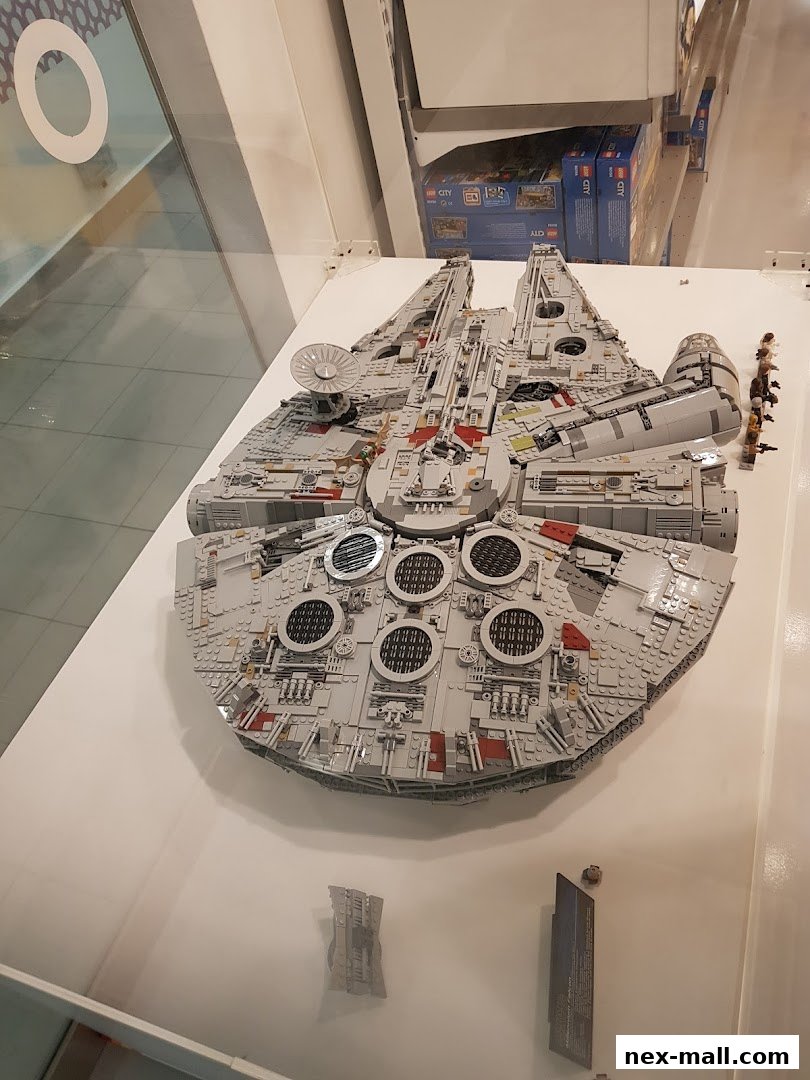 A large LEGO Millennium Falcon model displayed in a store with other LEGO sets in the background.