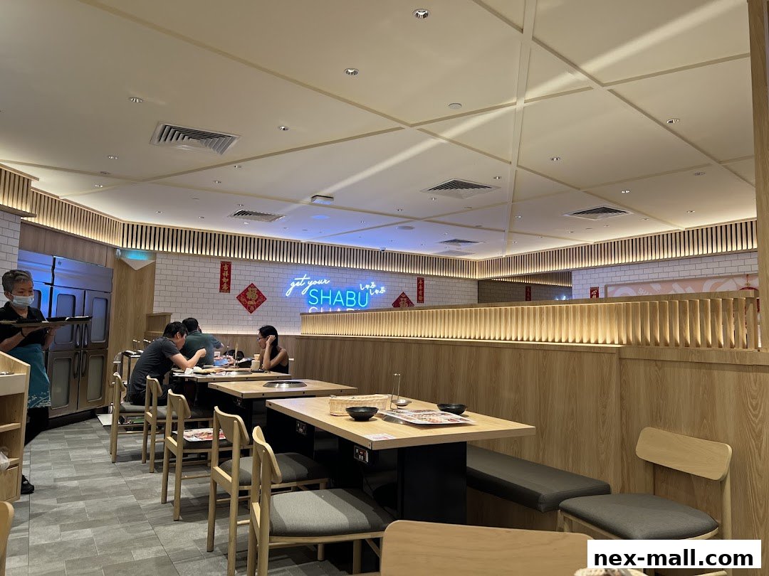 Interior view of a modern Japanese shabu-shabu restaurant with diners and staff.