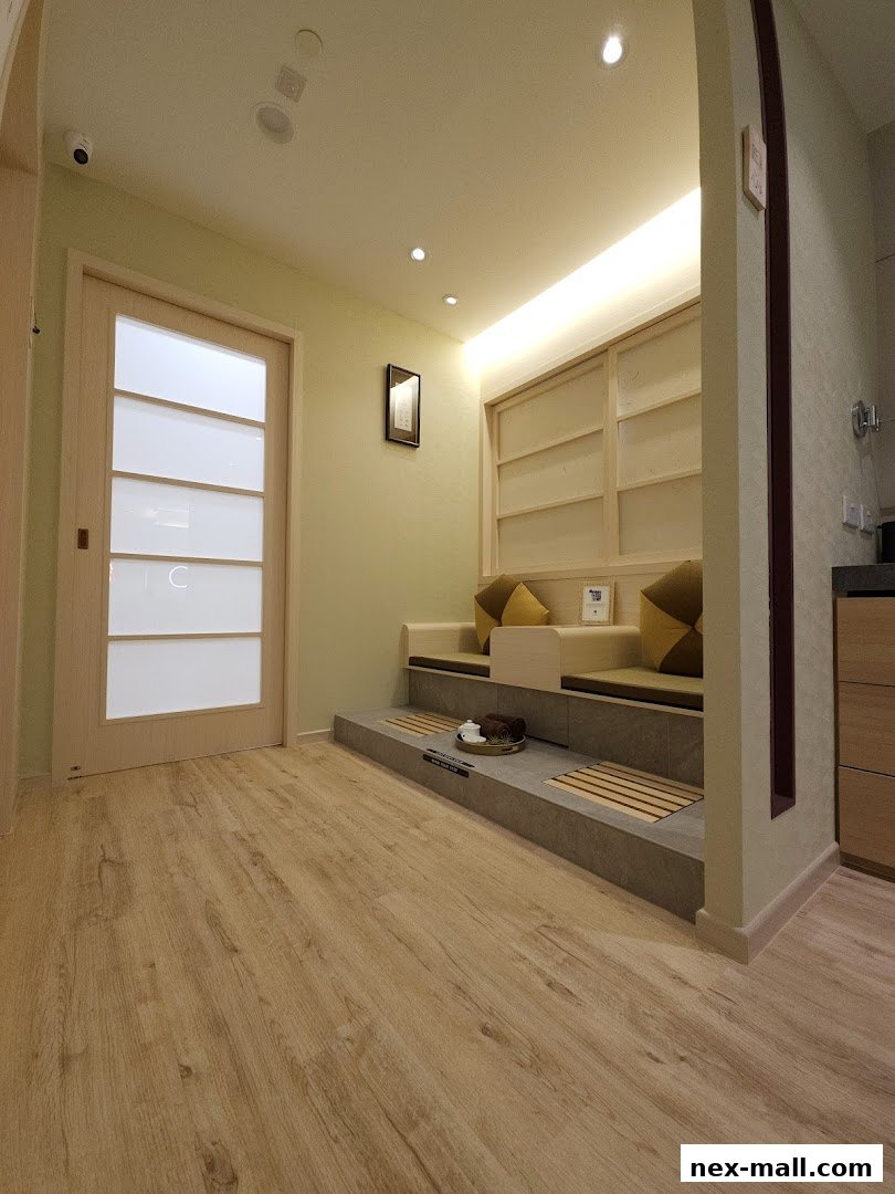 Interior view of a spa waiting area with seating, foot baths, and a wooden door.