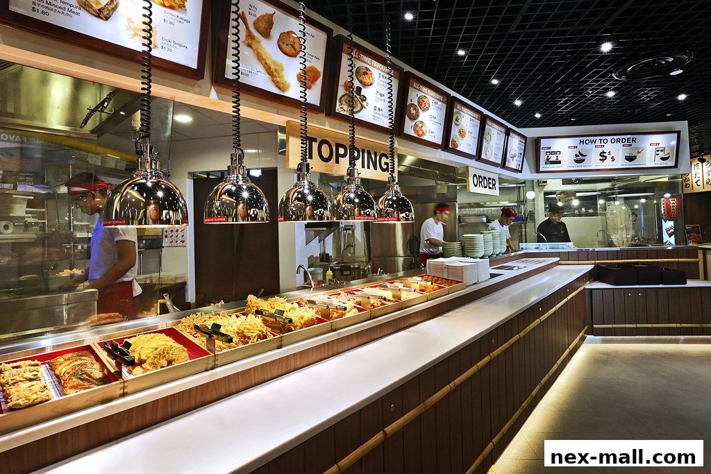 A view of a Japanese restaurant counter with various food items and staff preparing orders.