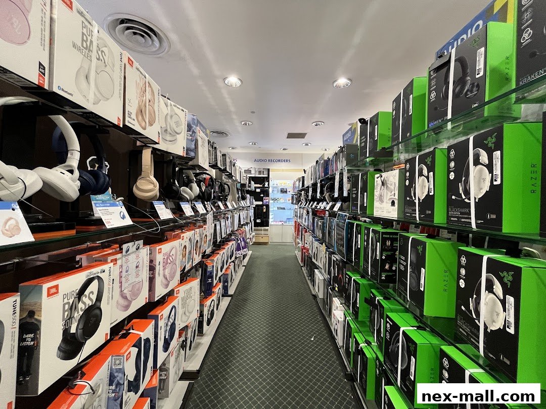 A wide selection of headphones and audio equipment displayed on shelves in a retail store.