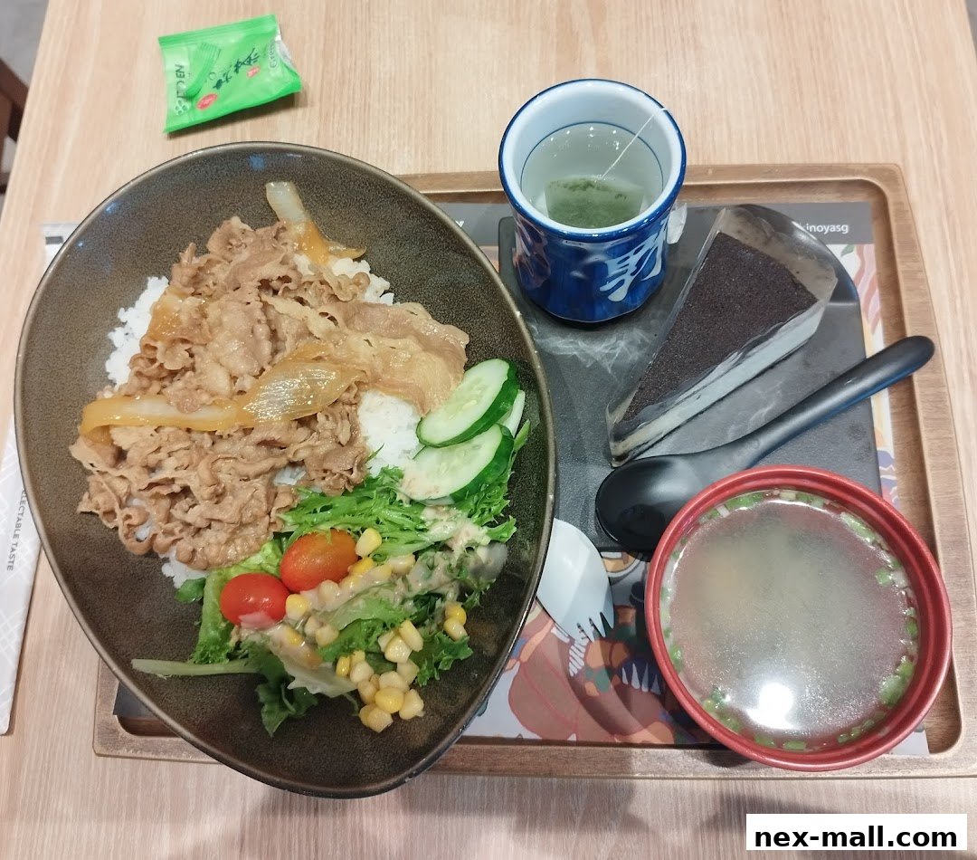 A Yoshinoya meal set featuring beef bowl, salad, soup, tea, and dessert on a tray.