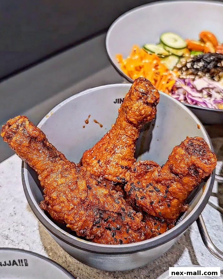 Crispy Korean fried chicken drumsticks served in a bowl with sesame seeds.