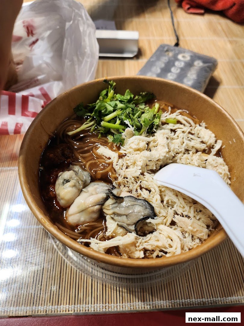 A bowl of Taiwanese street food noodles with oysters and shredded chicken.