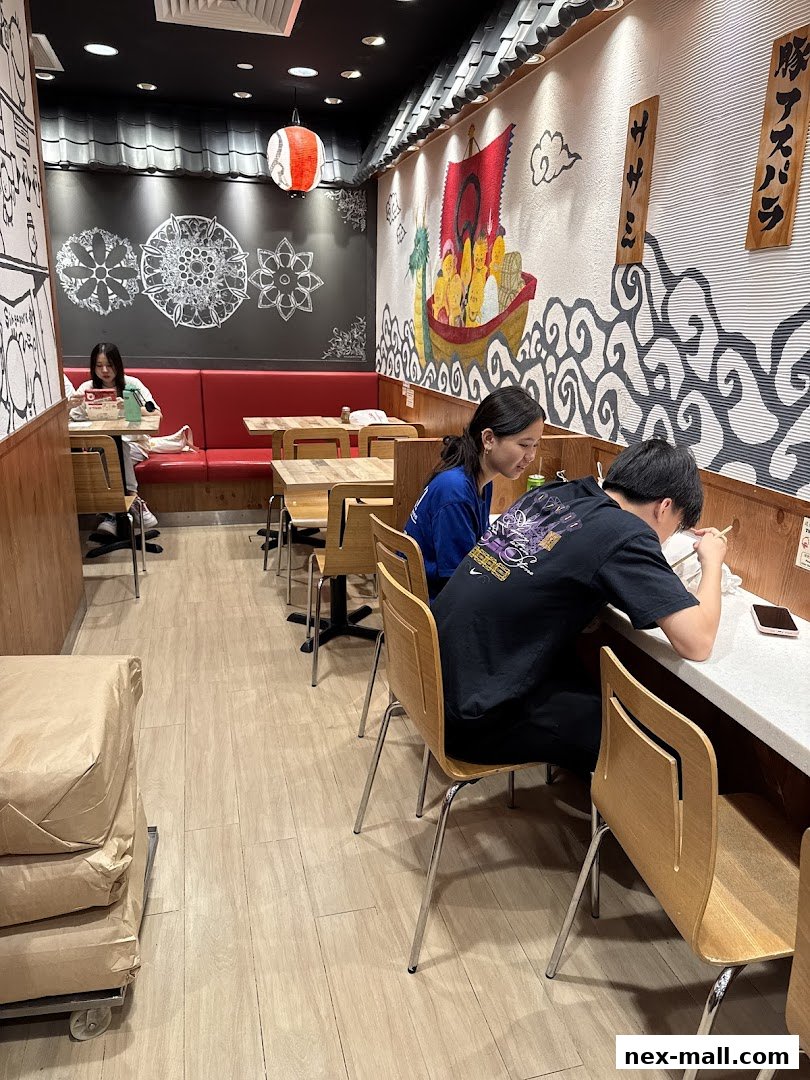 Diners enjoy a meal inside a Japanese restaurant with vibrant wall art and traditional decor.