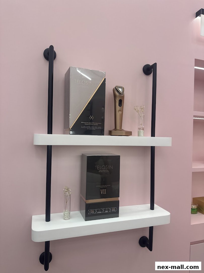 Shelves display Telosin anti-aging devices and skincare products against a pink wall.