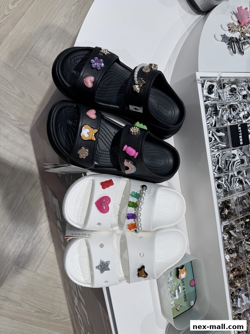 Crocs sandals decorated with various colorful Jibbitz charms, displayed in a store.