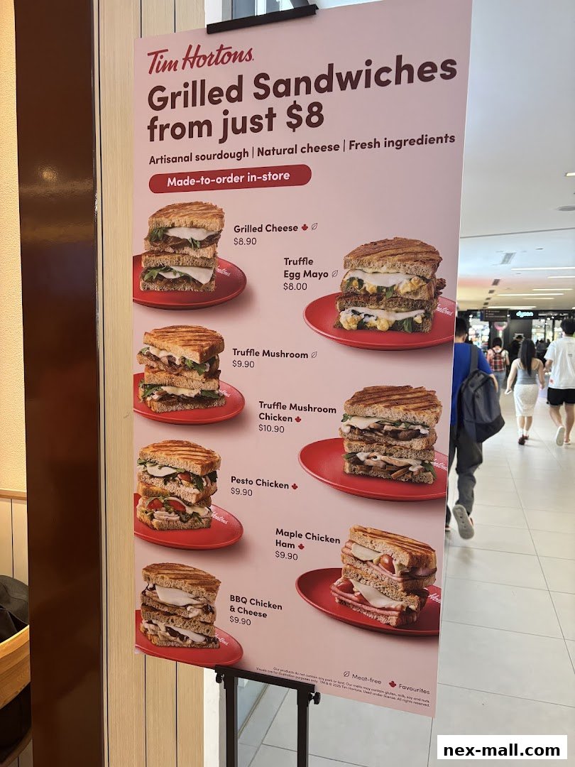 A Tim Hortons sign displaying various grilled sandwiches with their prices and images.