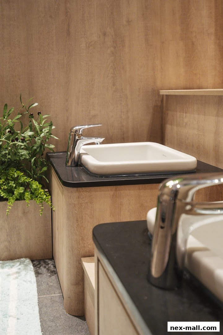 A modern bathroom sink with a chrome faucet and a potted plant.