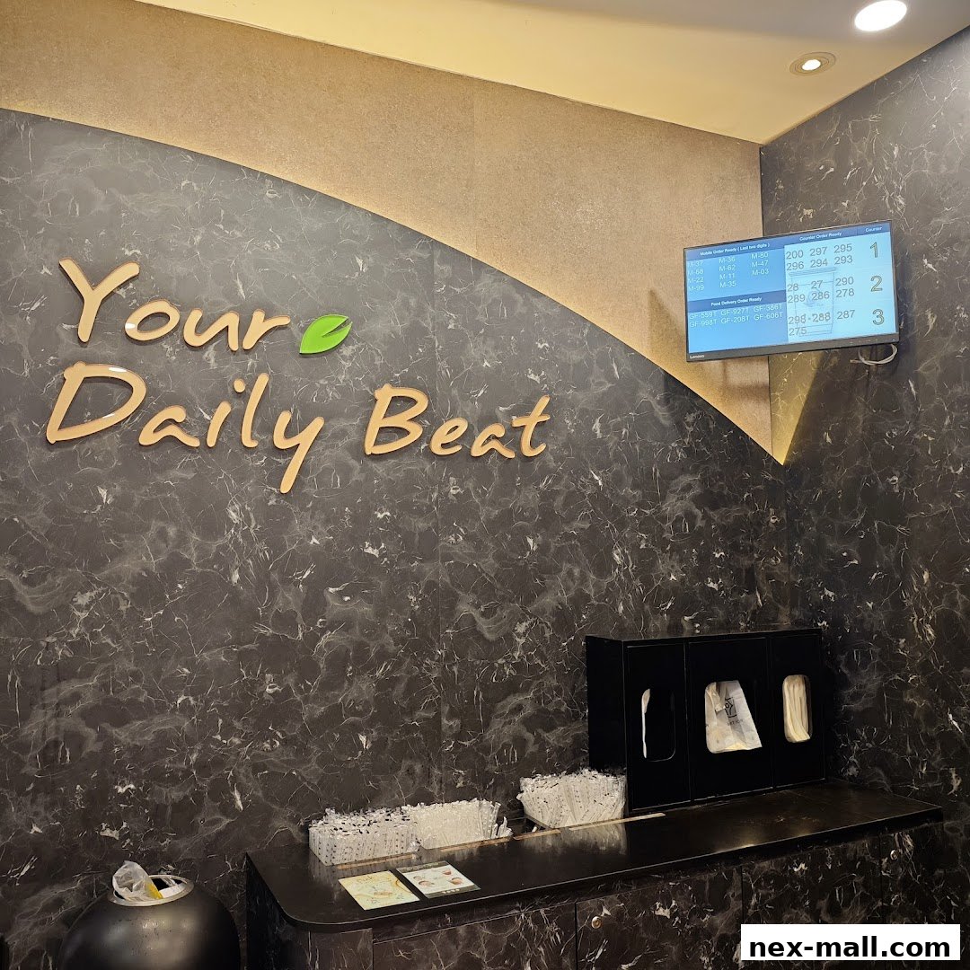 The interior of a shop with the "Your Daily Beat" logo and a digital display showing order numbers.