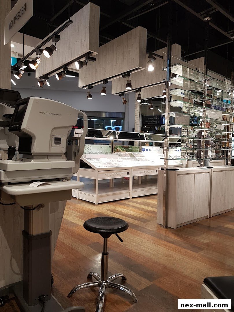 Interior of an optical shop with eye examination equipment and display shelves of glasses.